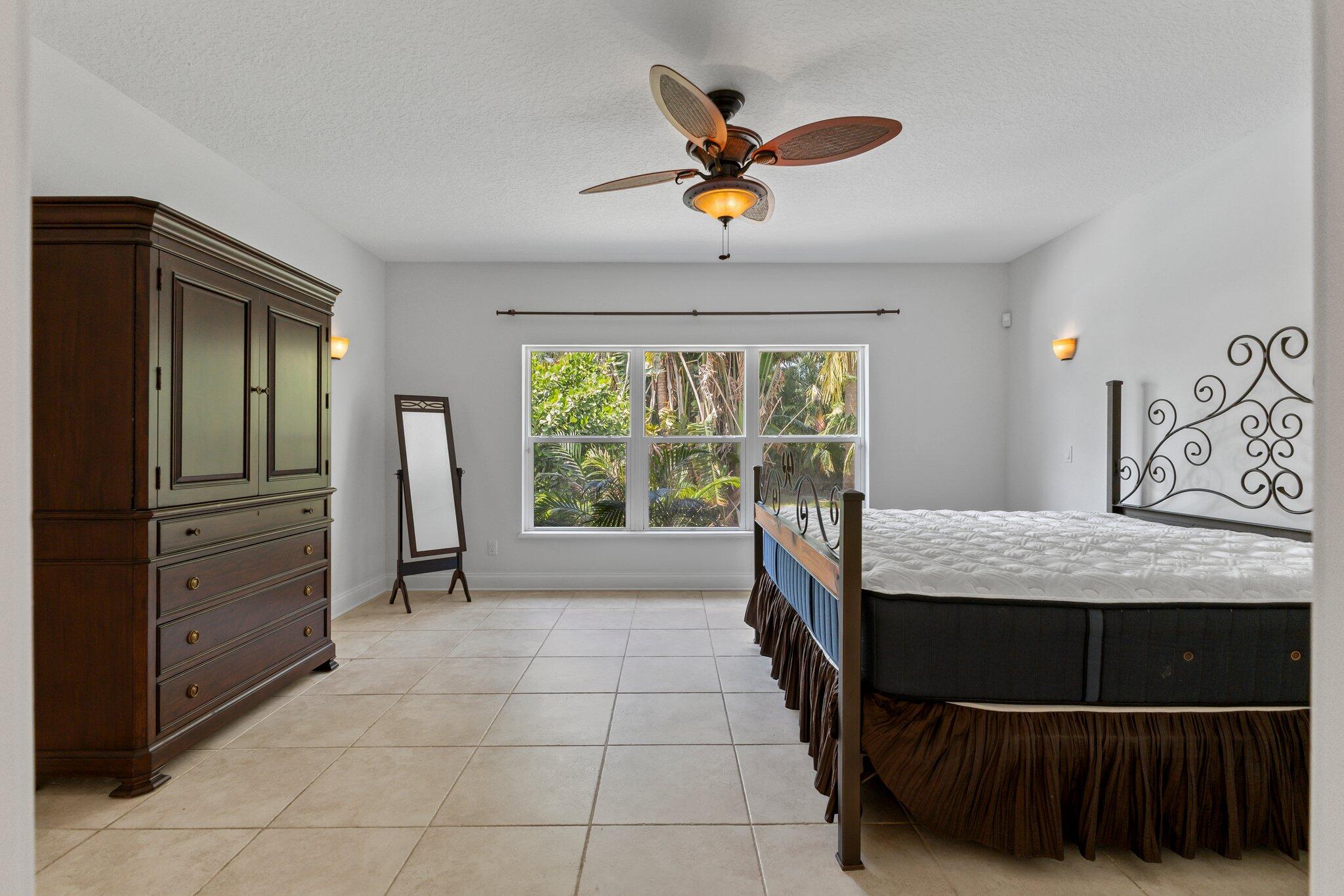 1293 Southwest Heather Terrace Stuart, FL 34997 - Photo 22 of 80 a bedroom with a bed and a large window