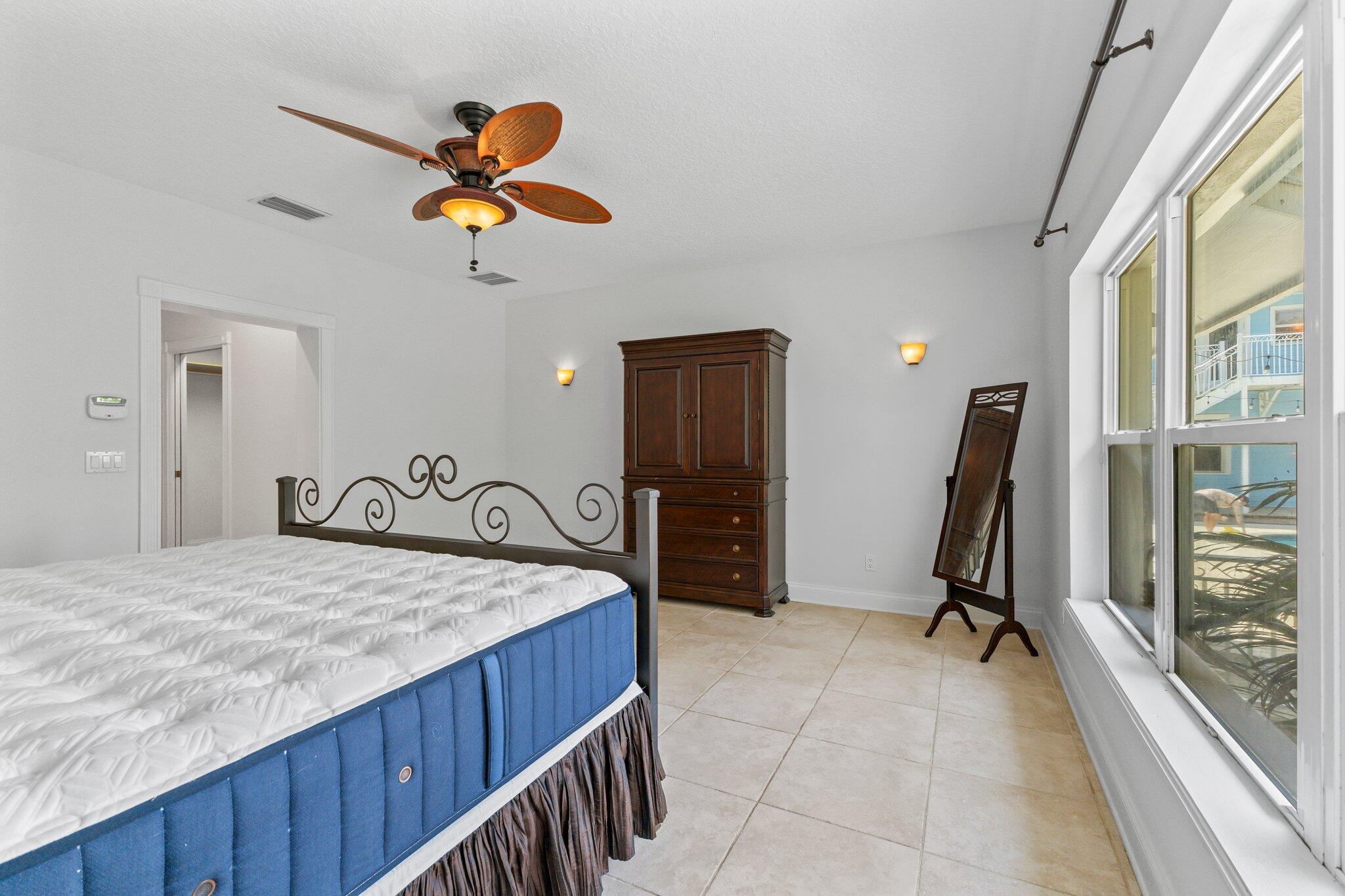 1293 Southwest Heather Terrace Stuart, FL 34997 - Photo 23 of 80 a bedroom with a bed and a large window