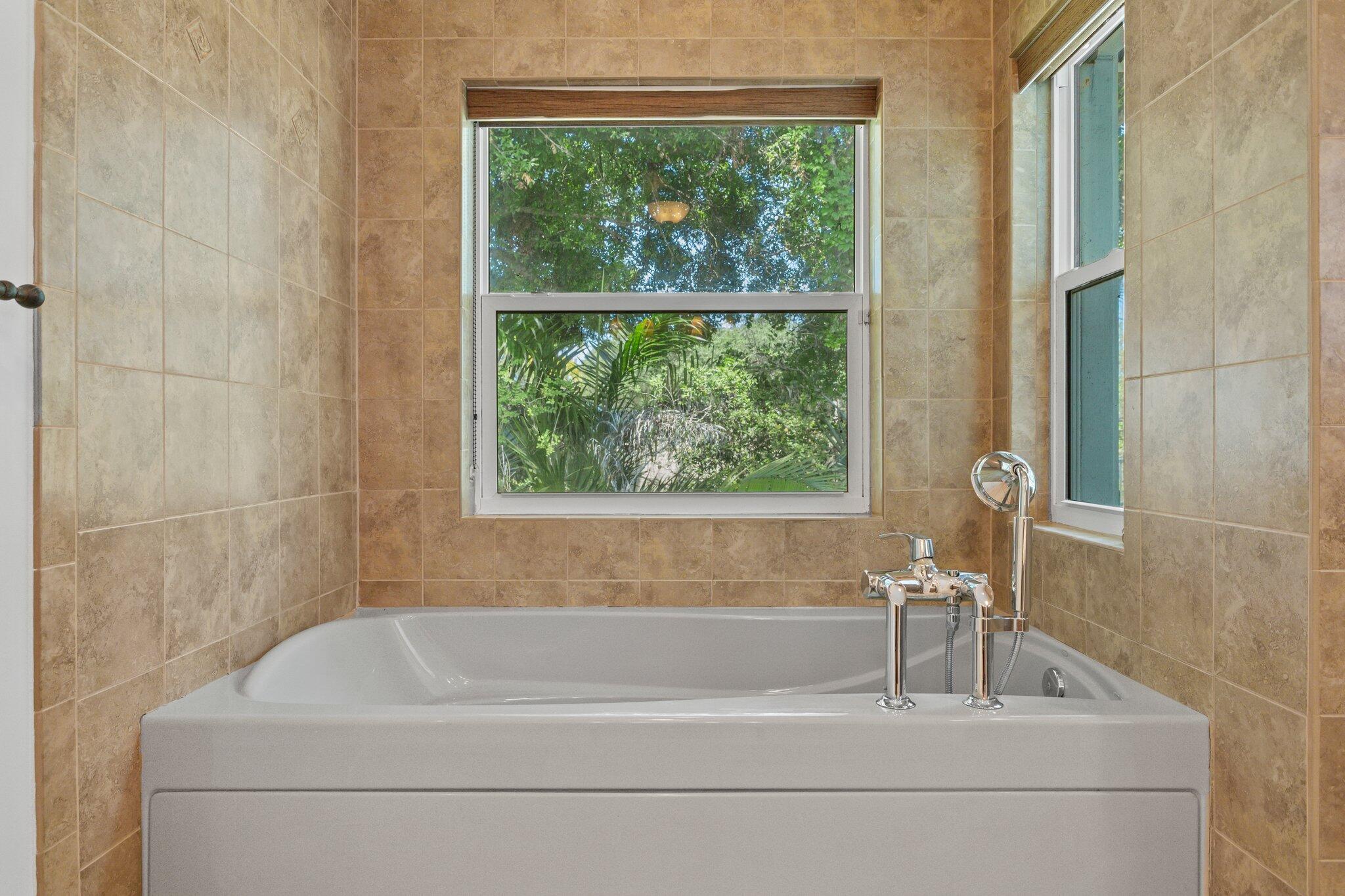1293 Southwest Heather Terrace Stuart, FL 34997 - Photo 27 of 80 a bathroom with a bathtub