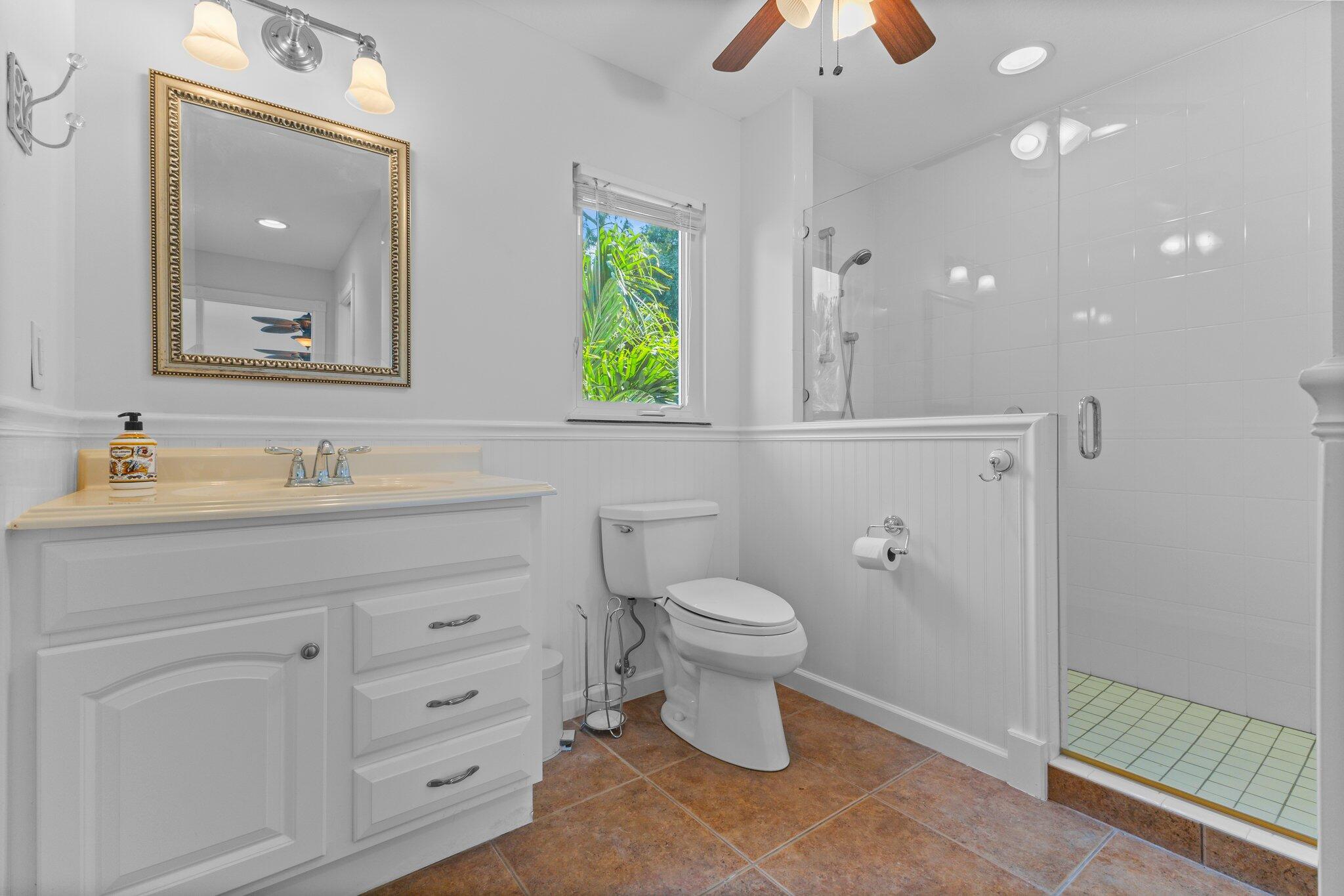 1293 Southwest Heather Terrace Stuart, FL 34997 - Photo 47 of 80 a bathroom with a toilet a sink a vanity and mirror