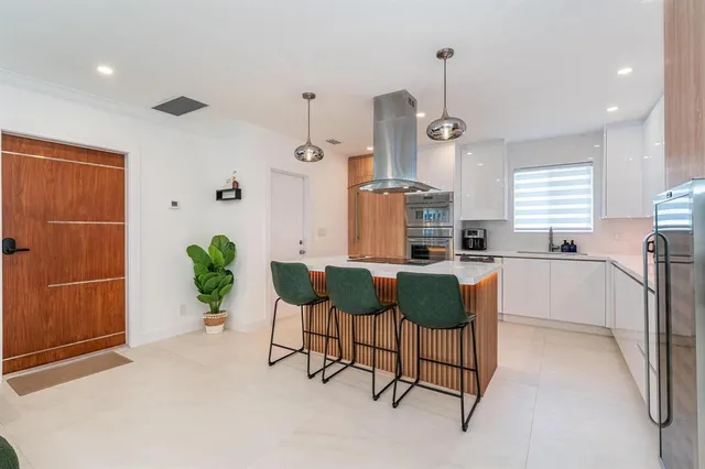 a spacious bedroom with a large bed and a chandelier