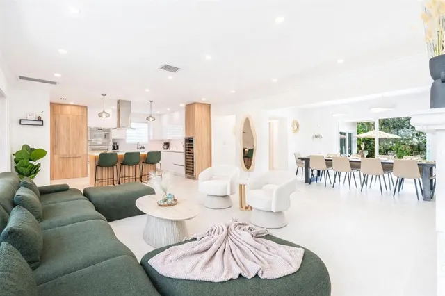 a dining room with furniture and a large window