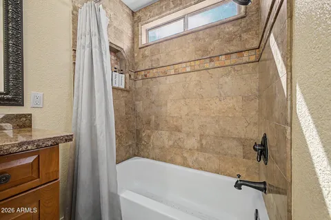 a bathroom with a granite countertop sink a vanity and shower