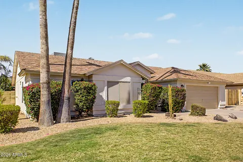 a front view of a house with a garden and yard