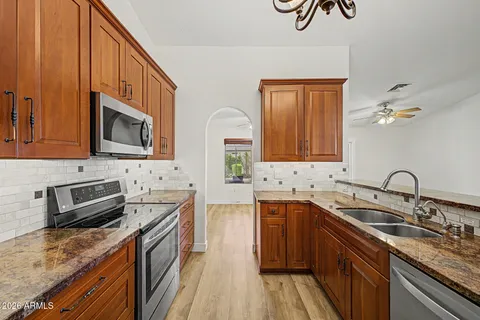 a kitchen with stainless steel appliances granite countertop a sink stove and refrigerator