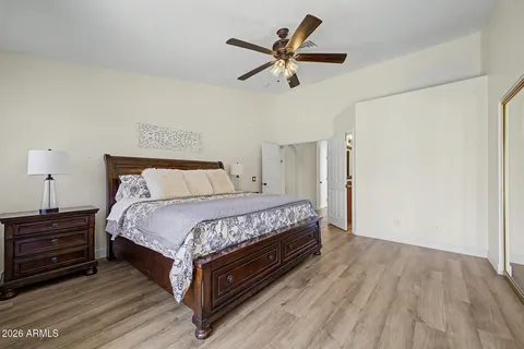 a bedroom with a bed a dresser and a ceiling fan