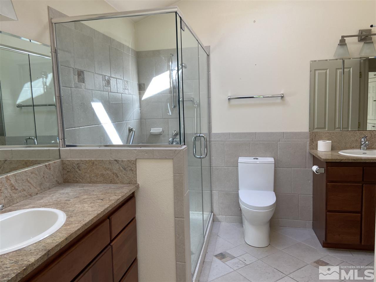 655 East Riverview Circle Reno, NV 89509 - Photo 11 of 13 a bathroom with a granite countertop sink a toilet a mirror and bathtub