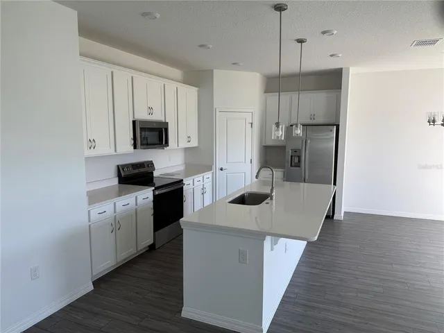a kitchen with kitchen island white cabinets and stainless steel appliances