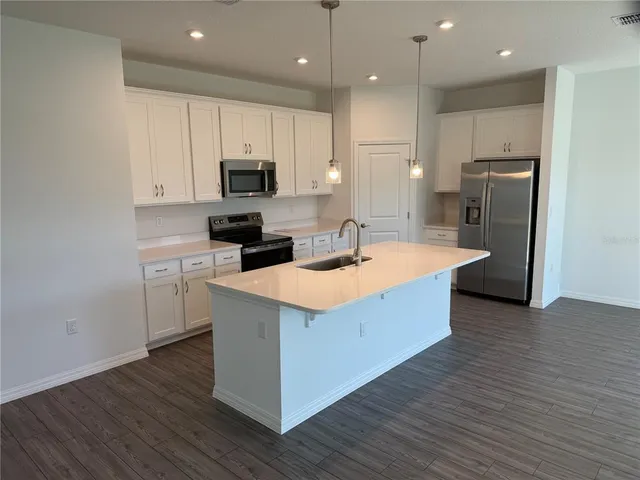 a kitchen with kitchen island sink stove and refrigerator