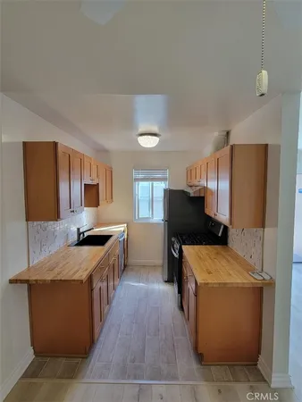 a large kitchen with a stove a sink a refrigerator and a microwave