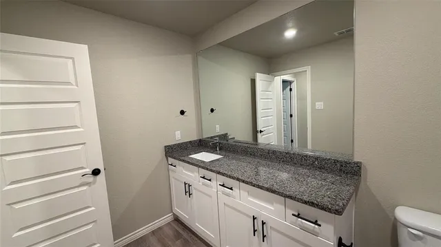 a bathroom with a granite countertop sink and a mirror