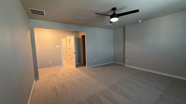 an empty room with ceiling fan and window