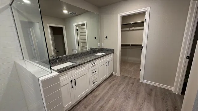a bathroom with a shower sink and mirror