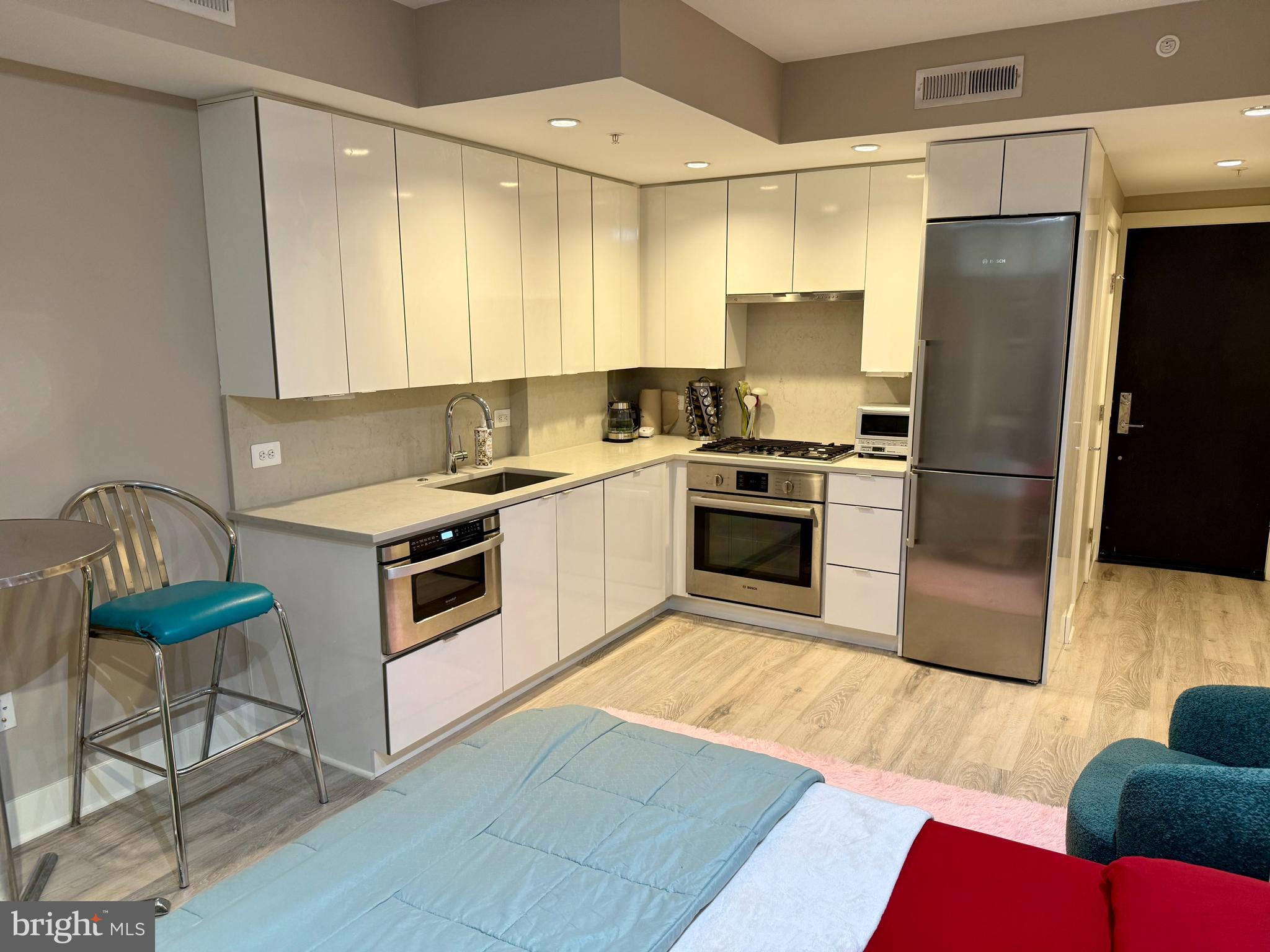 1311 13th Street Northwest, Unit T05 Washington, DC 20005 - Photo 7 of 17 a kitchen with stainless steel appliances granite countertop a stove a sink and a refrigerator
