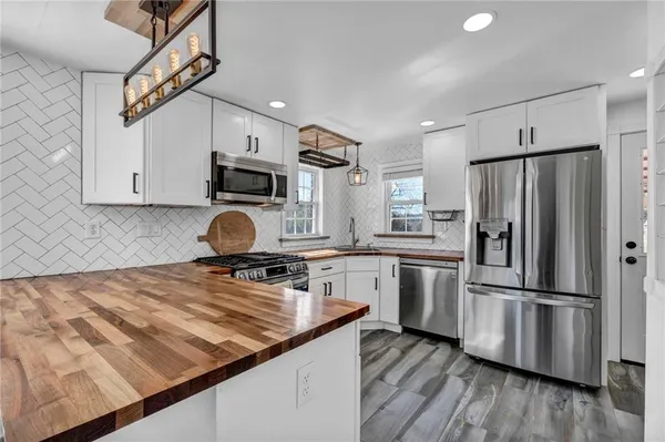 a view of kitchen with stainless steel appliances granite countertop a sink and a stove
