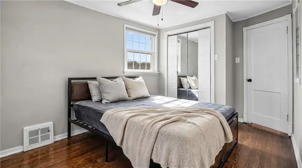 a living room with hard wood floors and a ceiling fan