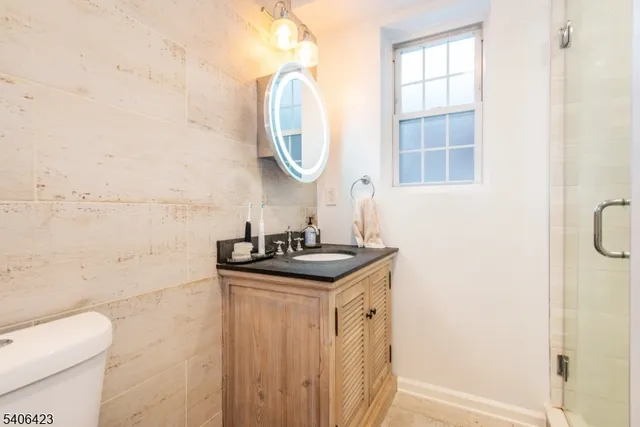 a bathroom with a granite countertop sink a toilet and a mirror