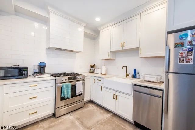 a kitchen with white cabinets stainless steel appliances and sink