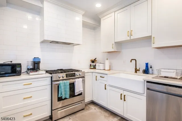 a kitchen with cabinets appliances a sink and a counter top