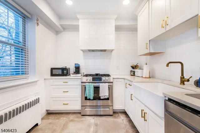 a kitchen with white cabinets and appliances