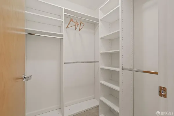 a view of walk in closet with empty racks