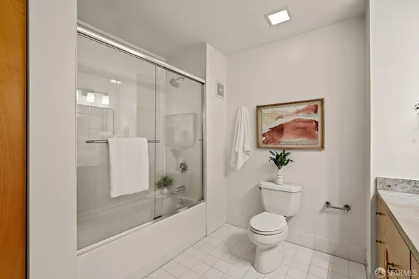 a bathroom with a granite countertop toilet a sink and a mirror
