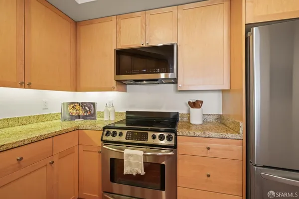 a kitchen with stainless steel appliances granite countertop a stove a microwave and a sink