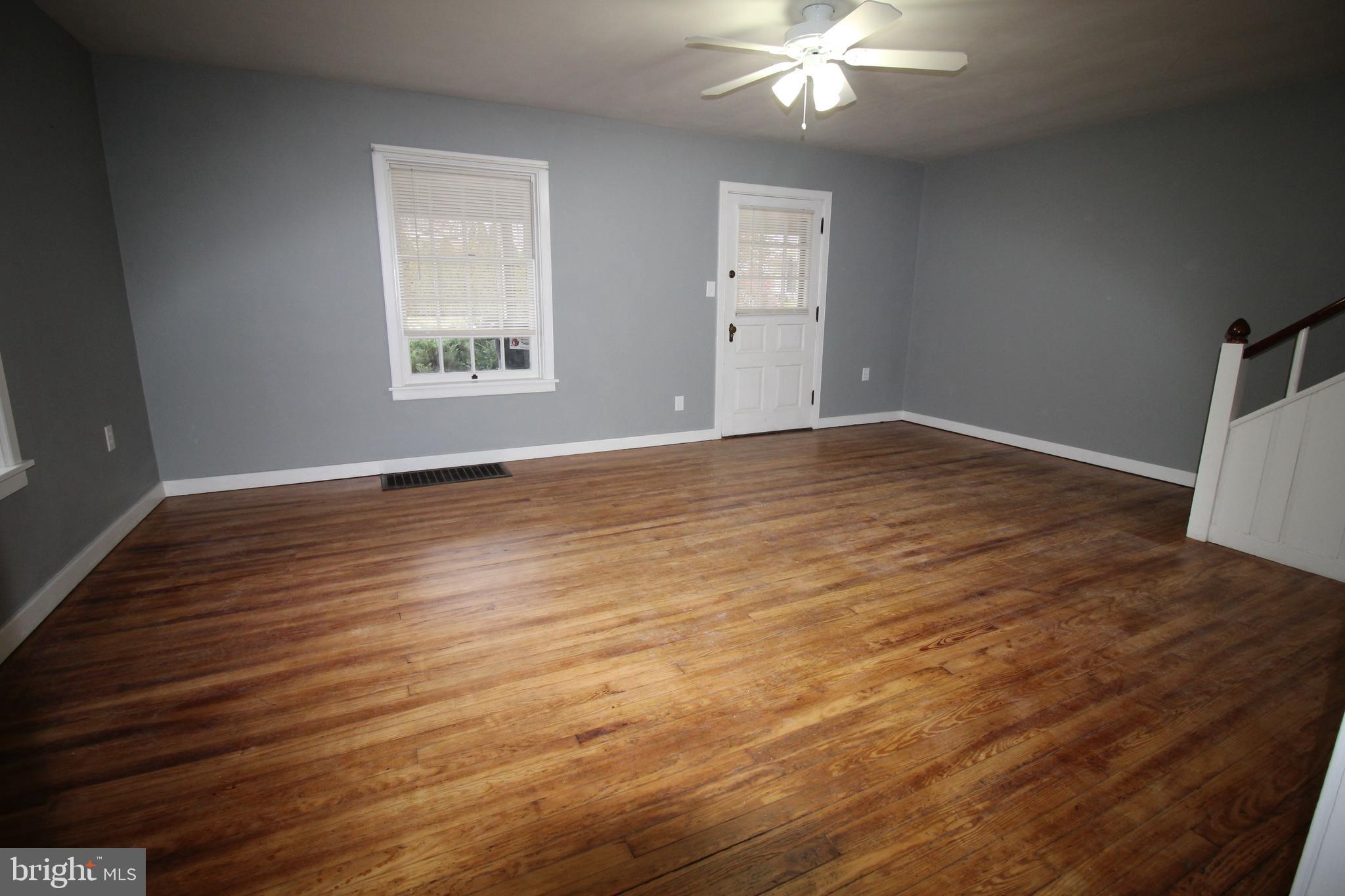 1076 Main Street East Earl, PA 17506 - Photo 3 of 11 a view of an empty room with wooden floor and a window