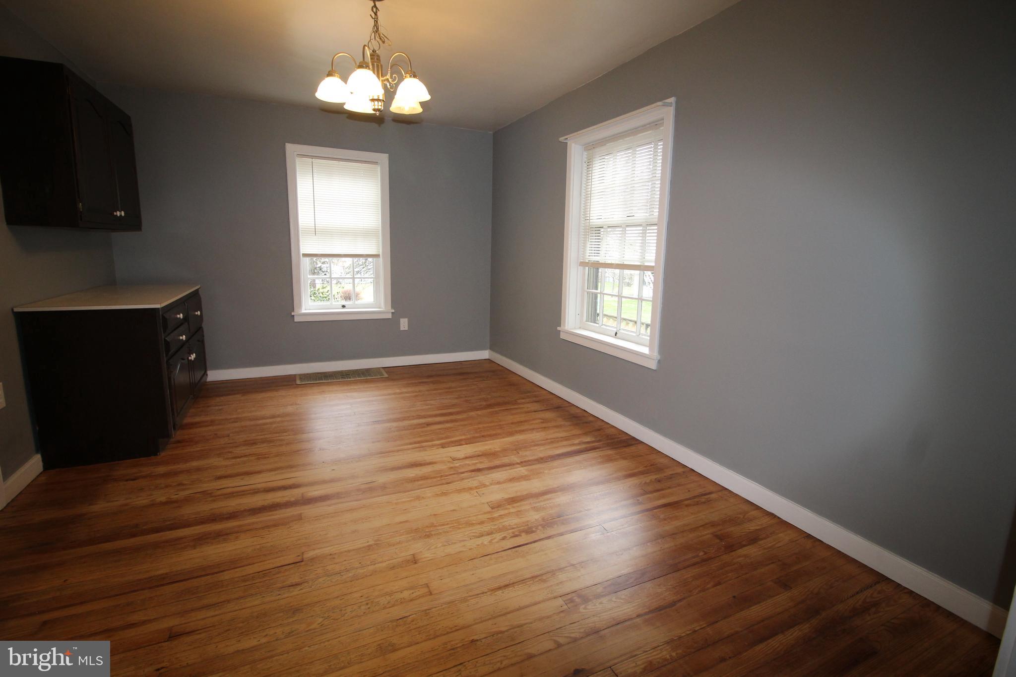 1076 Main Street East Earl, PA 17506 - Photo 6 of 11 an empty room with wooden floor chandelier and windows
