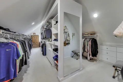 a spacious bedroom with a large bed and a chandelier