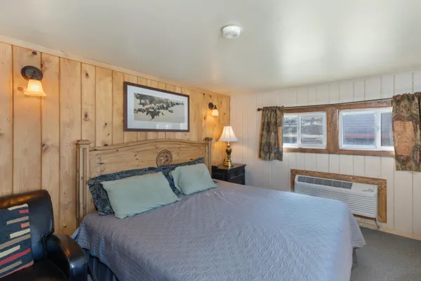 a bedroom with a bed and a painting on the wall