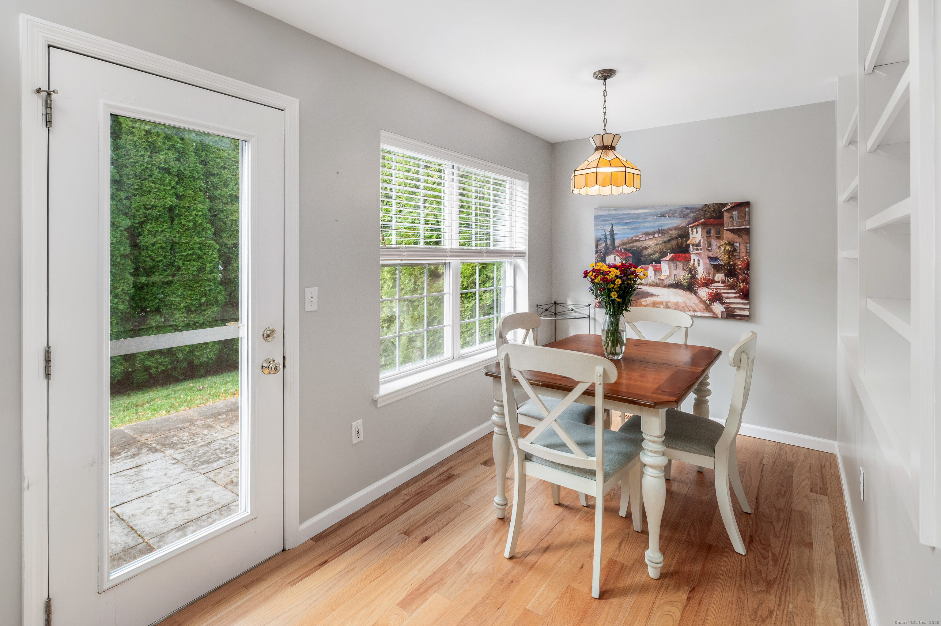 596 Glenbrook Road, Unit 36 Stamford, CT 06906 - Photo 9 of 25 a dining room with wooden floor a chandelier a glass table and chairs