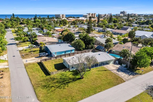 an aerial view of a house with swimming pool and ocean view