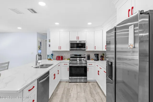 a kitchen with a sink stainless steel appliances and white cabinets