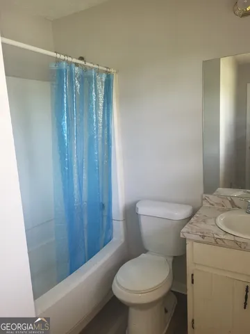 a white toilet sitting next to a shower