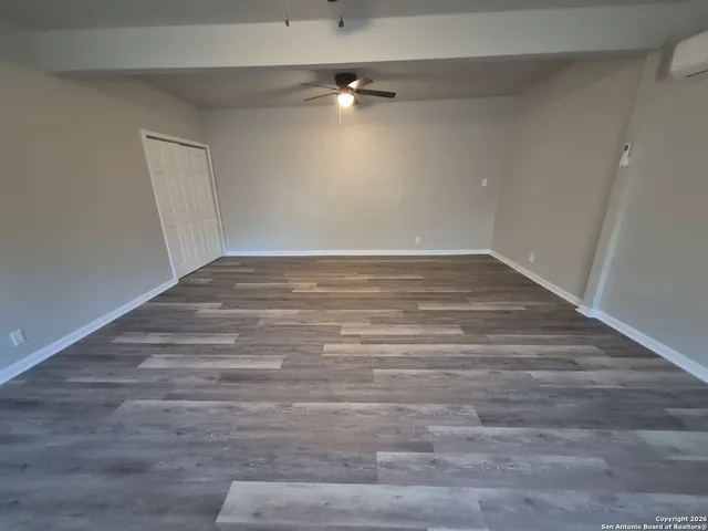 a view of an empty room with wooden floor