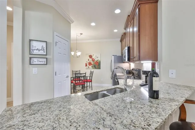 a dining room with wooden floor a chandelier a wooden table and chairs