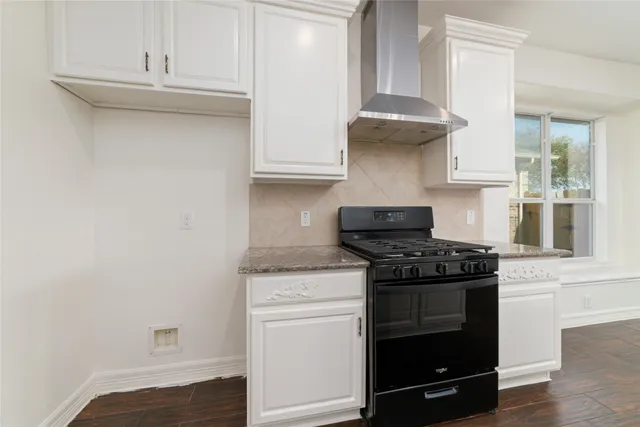 a kitchen with stainless steel appliances granite countertop white cabinets and a stove