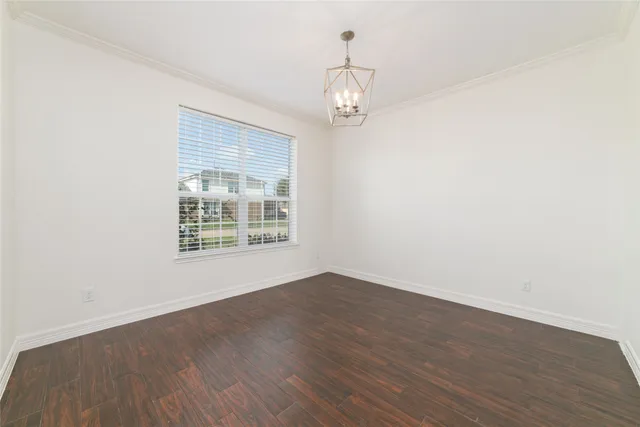 an empty room with wooden floor and window