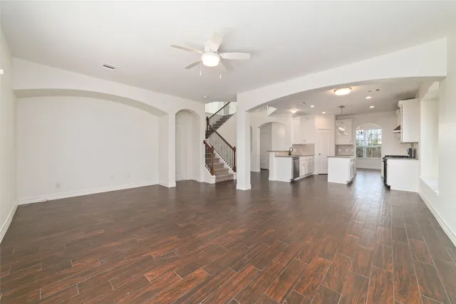 a view of a hallway with wooden floor and a kitchen space
