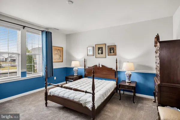 a bedroom with a bed lamp and a window