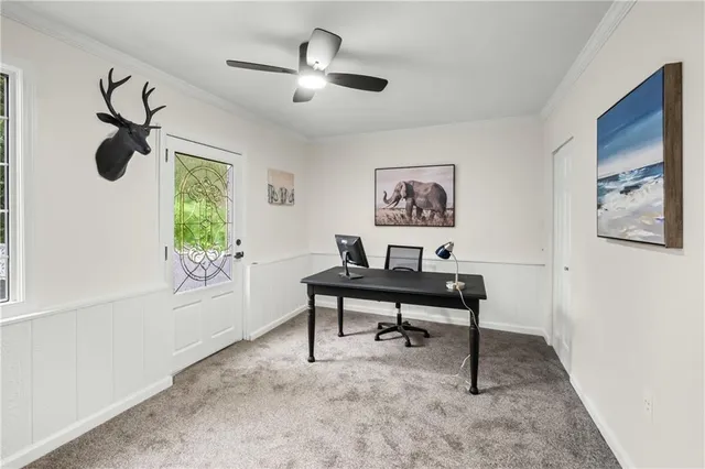 a view of a workspace with furniture and a window
