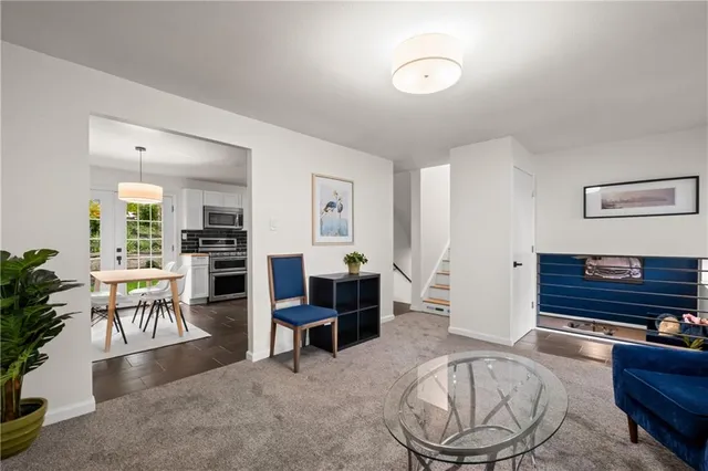 a living room with furniture a dining table and a piano next to a window
