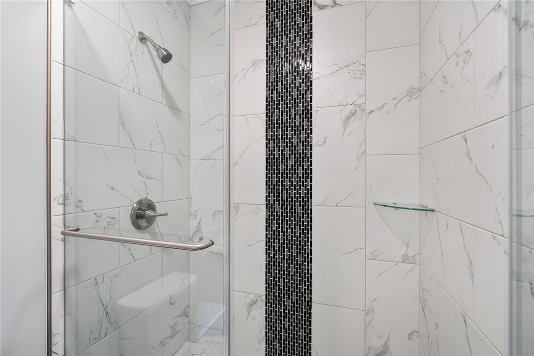 303 Regency Circle Anderson, SC 29625 - Photo 29 of 50 This sleek shower features modern tile work and a convenient glass shelf.