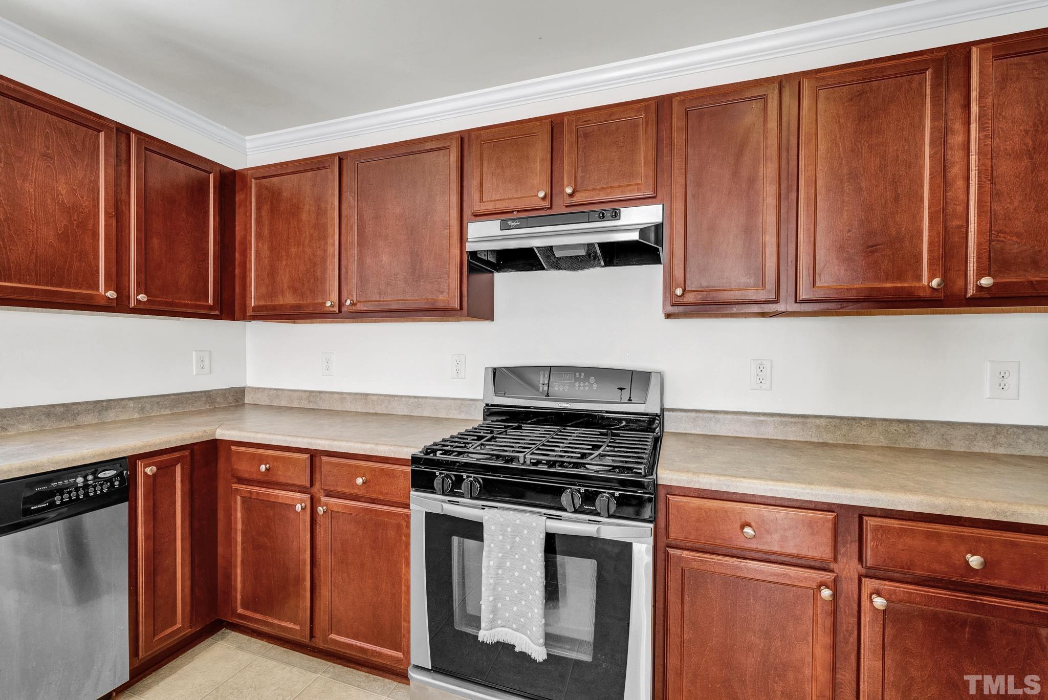 209 Lodestone Drive Durham, NC 27703 - Photo 11 of 30 a kitchen with granite countertop wooden cabinets and a stove top oven