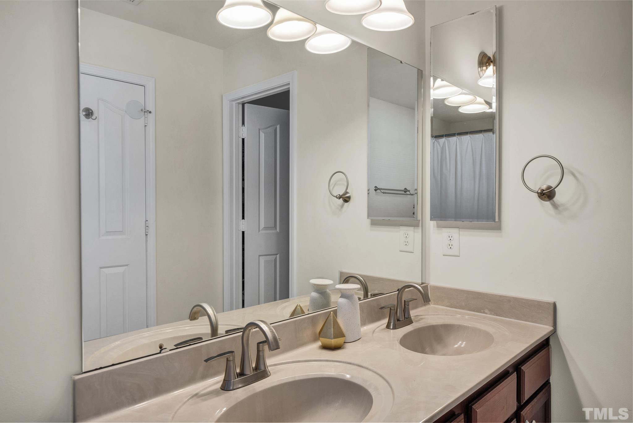 209 Lodestone Drive Durham, NC 27703 - Photo 20 of 30 a bathroom with double vanity sinks and a mirror