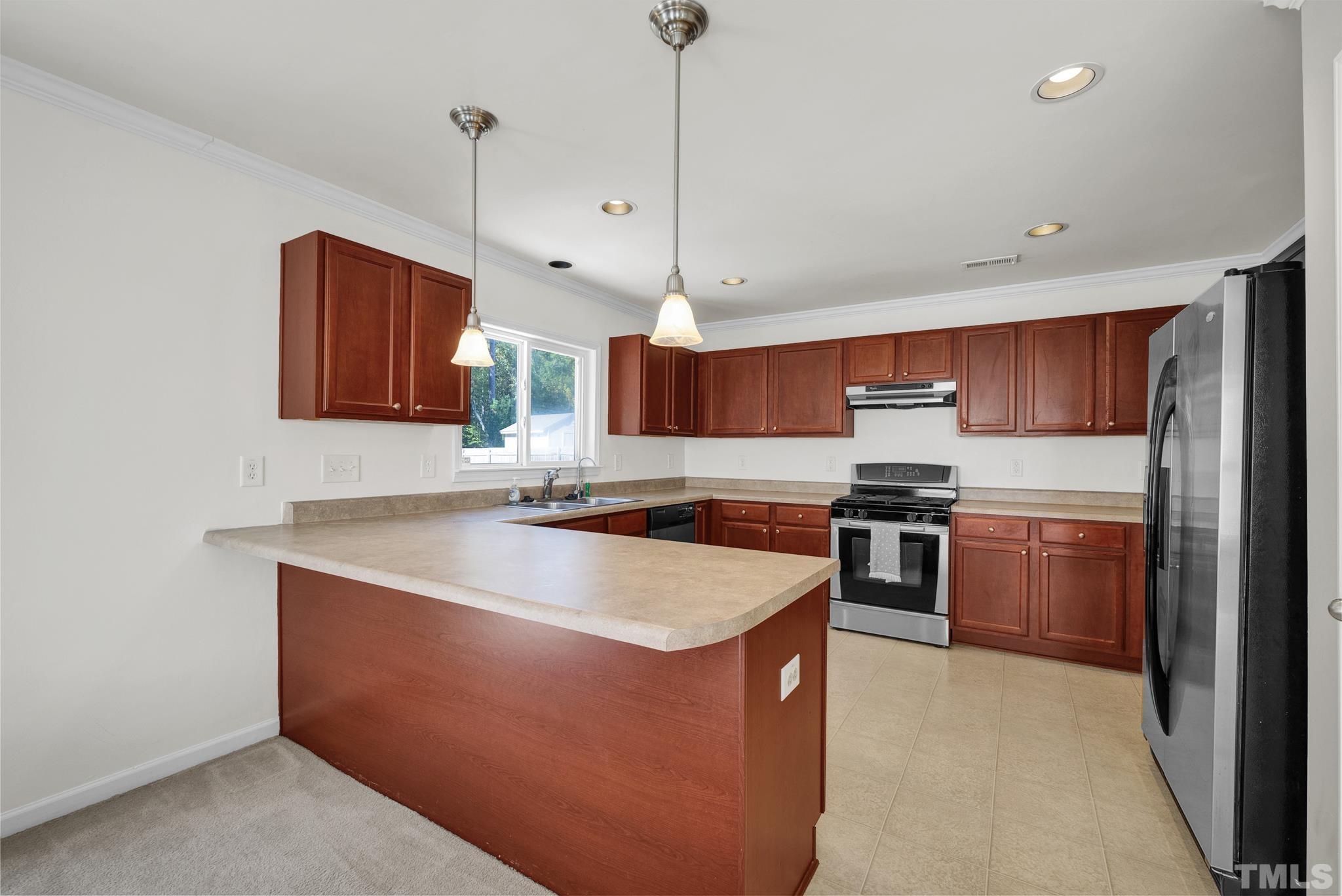 209 Lodestone Drive Durham, NC 27703 - Photo 9 of 30 a kitchen with stainless steel appliances granite countertop a sink a stove and a refrigerator