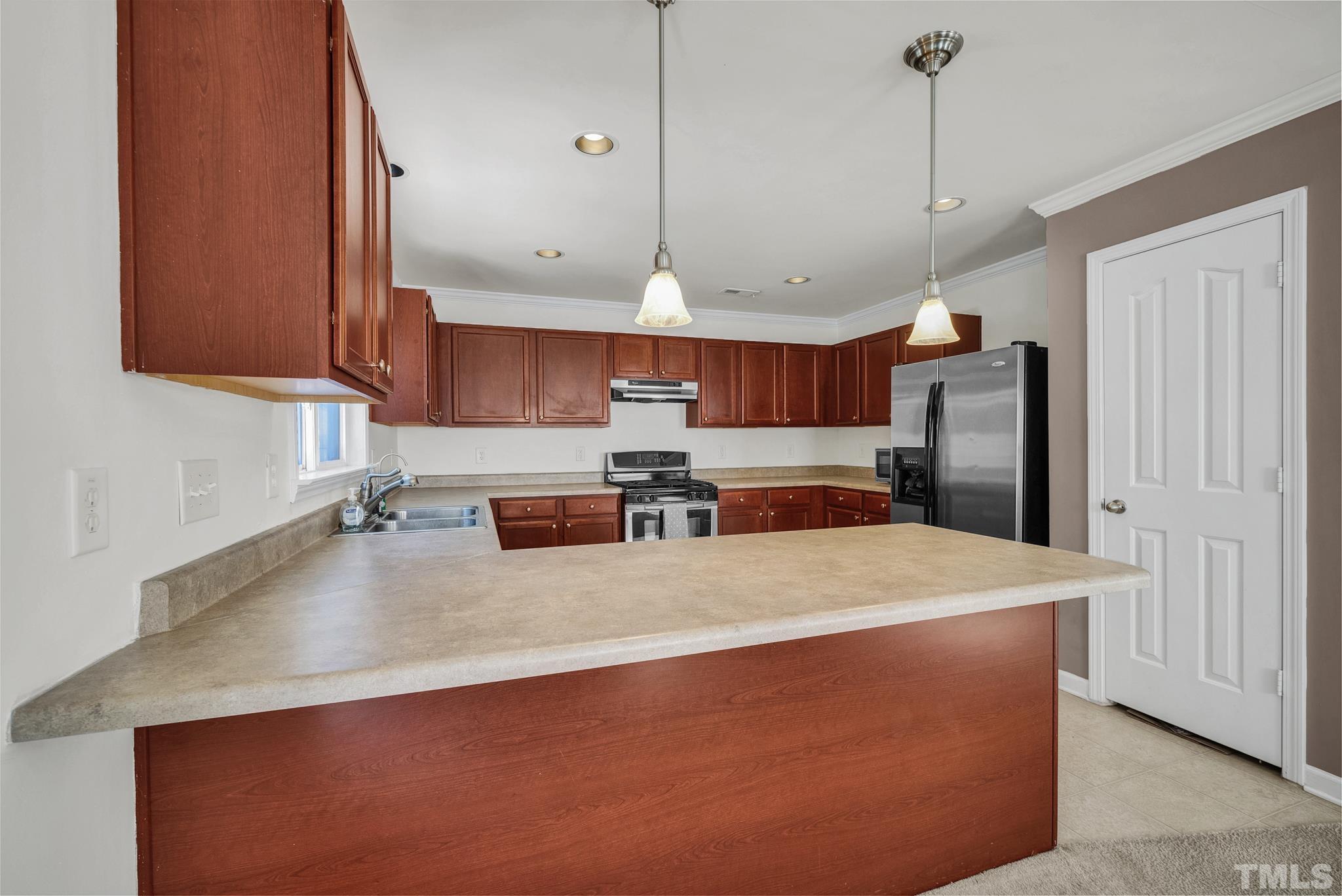 209 Lodestone Drive Durham, NC 27703 - Photo 10 of 30 a large kitchen with stainless steel appliances a large counter top a stove and a refrigerator