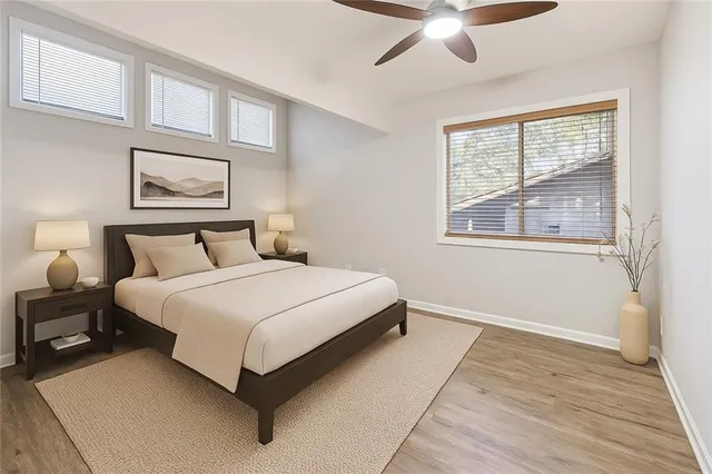 a bedroom with a bed and window with wooden floor