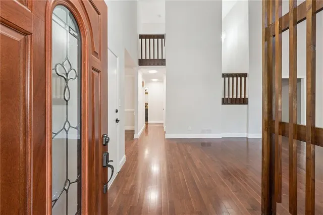 a view of a hallway with wooden floor and staircase